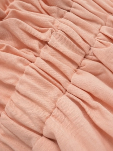 Vista macro della trama del tessuto a punto smock rosa chiaro e dettagli elastici