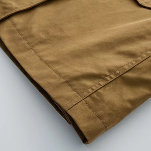 Detail of khaki twill cotton jacket showing durable double stitching and premium fabric texture