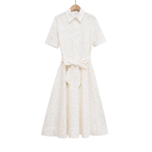 Macro view of white eyelet embroidery detail and button closure on shirt dress