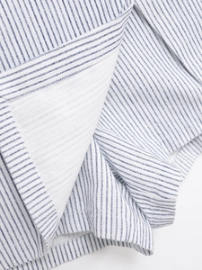 Gros plan sur un tissu à rayures verticales bleues et blanches avec détails lurex