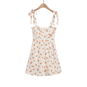 Detailed view of summer dress featuring orange prints and adjustable bow shoulder straps