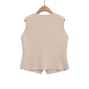 Détails de la maille fine et de l'ourlet asymétrique du gilet sans manches beige clair