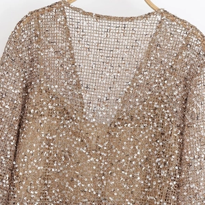 Détails de paillettes dorées champagne sur une robe de soirée en maille avec col en V profond