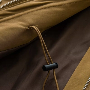 Detail of adjustable drawstring toggle and metallic zipper on utility cargo jacket
