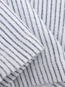 Gros plan sur un tissu à rayures bleues avec fils métalliques argentés et texture drapée