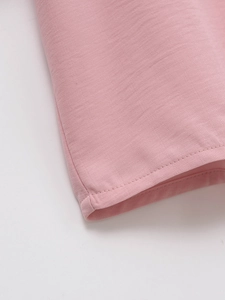 Close-up of pink knit shirt showing detailed double-needle stitching and fabric texture