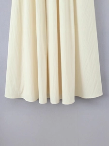 Elegant sleeveless cream long dress featuring a floral design and fluid pleated hemline