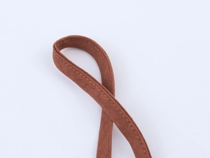Macro detail of brown silky strap featuring precise double-needle stitching on the edge