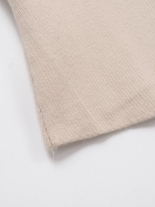 Gros plan sur la texture en tricot côtelé vertical d'un gilet en maille beige à col en V