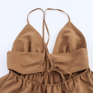 Detail of caramel backless halter dress showing delicate cross tie and ruched elastic design