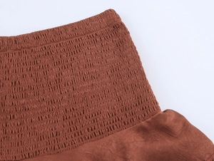 Close-up of rust brown Y2K tiered skirt with elastic shirring detail and ruffle texture