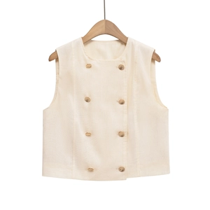 Close-up of beige double-breasted vest with eight elegant gold metal buttons