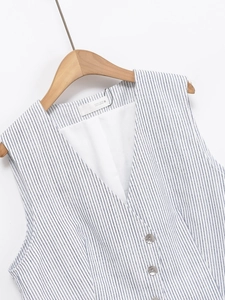 Gros plan sur le gilet à rayures bleues et blanches avec boutons et étiquette du col