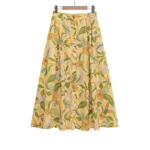 Détail d'une jupe midi fleurie à taille haute avec boutons sur le devant et imprimé