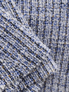 Detailed macro view of the premium blue and gold tweed fabric with metallic silk texture