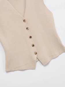 Détail du gilet en maille col V montrant la texture fine et cinq boutons décoratifs