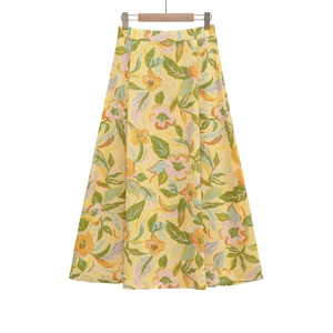 Détail de la jupe trapèze à taille haute avec tissu jaune et imprimés de fleurs orange