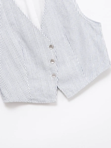 Détail d'un gilet à rayures bleues et blanches avec trois boutons et col en V