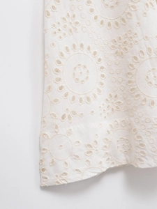 Close-up detail of white eyelet embroidery on the hem of a short sleeve midi dress