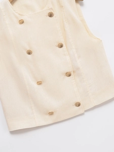 Detail of beige vest featuring double-breasted gold buttons and linen blend texture