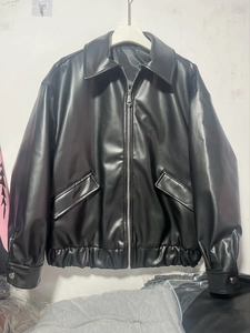 Detail view of black PU leather bomber jacket featuring lapel collar and metal zipper