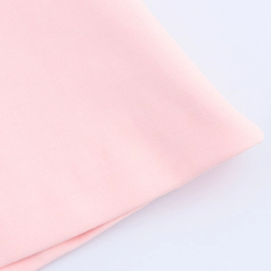 Detailed macro view of light pink textile fabric with fine weave and soft texture
