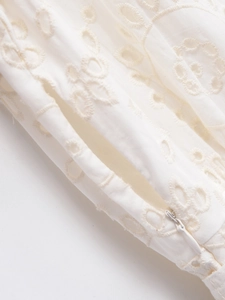 Detail of white cotton eyelet embroidery and invisible zipper on the summer dress