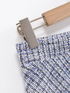 Detail shot of tweed fabric texture with blue and white woven pattern and gold silk thread