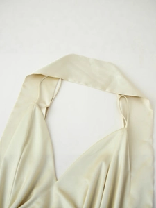 Champagne satin halter dress with V-neck pleats and delicate thin straps on white background