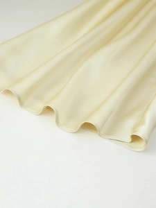 Elegant satin halter dress with silky texture and draped hemline for summer style