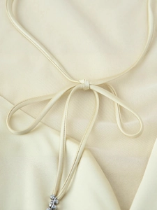 Champagne satin dress featuring halter neck tie with exquisite silver flower details