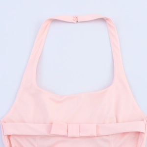 Detail view of pink halter neck top showing bow design and rear button closure