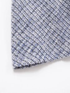 Close-up of multicolored tweed fabric with white, blue, black fibers and gold metallic threads