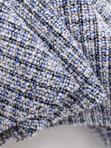 Macro view of blue and white tweed fabric with golden lurex thread for a premium texture