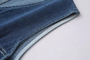 Détail macro du tissu denim indigo de qualité avec coutures précises et texture sergée