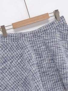 Detailed macro view of the blue and white tweed fabric texture and high waist skirt sewing