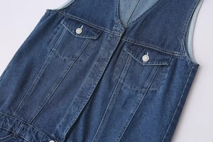 Détail d'une combinaison en denim bleu foncé avec col en V et coutures contrastées