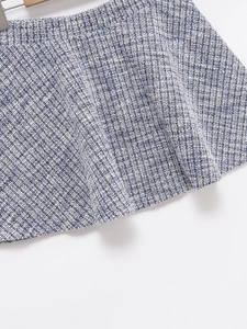 Detail shot of the blue and white tweed fabric texture on a high-waisted skirt