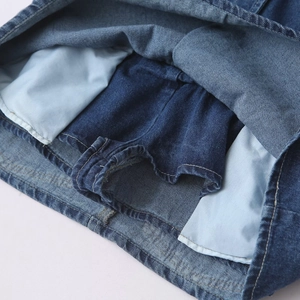 Détail montrant la doublure intérieure en jean et la poche latérale du combishort