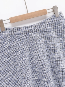 Close-up of blue and white tweed fabric texture with classic woven pattern on a skirt