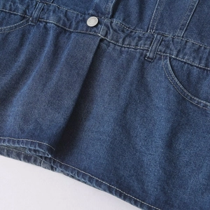 Détail de la taille d'une combinaison en jean avec bouton en métal et surpiqûres