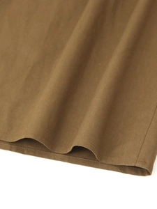 Détail macro du tissu marron et de la finition de couture sur l'ourlet de la robe