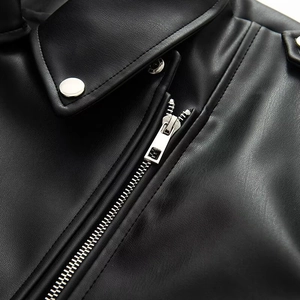 Detailed macro view of black faux leather jacket texture with silver metal zippers and buttons