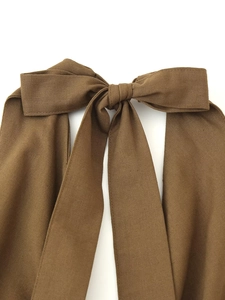 Détail d'un nœud en lin marron avec texture de tissu sur une robe d'été dos nu