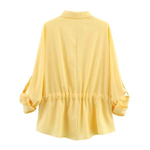 Detail of yellow V-neck shirt featuring adjustable drawstring waist and roll-up sleeves
