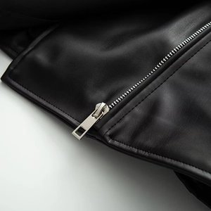 Detail of silver metal zipper and premium black faux leather texture on biker jacket