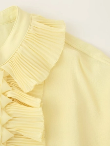 Detail of light yellow pleated collar and textured fabric on casual long sleeve shirt