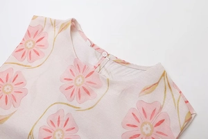 Detailansicht des Rundhalsausschnitts mit Blumendruck und Knopfverschluss am Sommerkleid