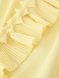 Detail of bright yellow pleated chiffon fabric with elegant ruffled edges for summer shirts
