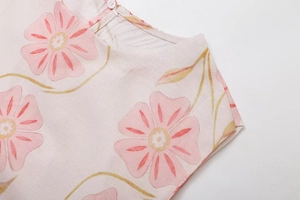 Detail des Kleidausschnitts mit Blumenmuster, Baumwoll-Leinen-Textur und Knopf hinten